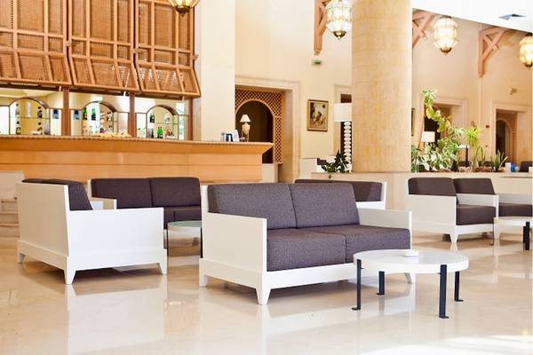Lobby des El Mouradi Hammamet Hotels mit weißen Möbeln und einem Tisch