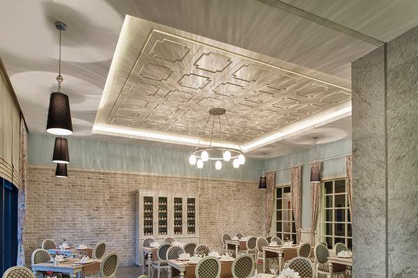 Innenansicht des Restaurants im Aska Lara Resort & Spa mit Tisch, Stühlen und dekorativen Deckenleuchten.