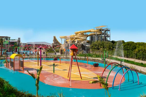 Wasserpark des Aska Lara Resort & Spa mit bunten Spielgeräten und einer großen Wasserrutsche im Hintergrund.