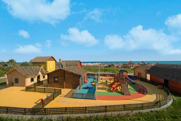 Außenansicht des Kinderspielplatzes im Aska Lara Resort & Spa mit bunten Spielgeräten und Hütten.