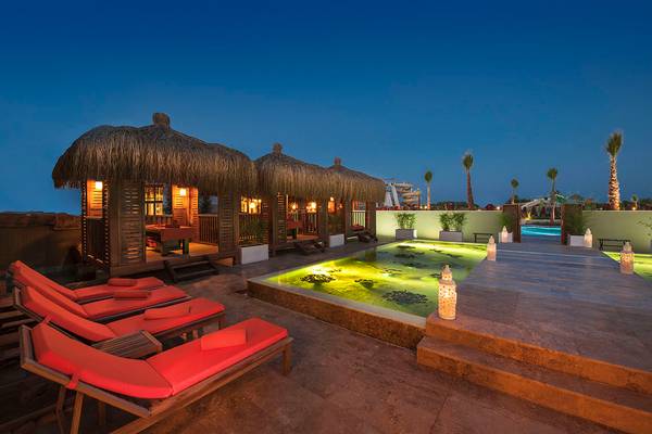 Nachtansicht der Terrasse im Aska Lara Resort & Spa mit beleuchteten Loungestühlen und einem kleinen Pool.