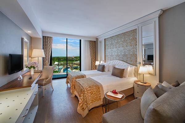 Hotelzimmer mit zwei Betten, Wohnzimmer und Balkon mit Poolblick im Aska Lara Resort & Spa.