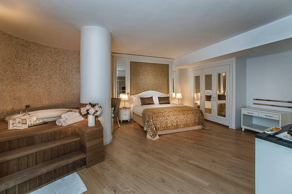 Hotelzimmer im Aska Lara Resort & Spa mit Bett, Badewanne und Essbereich.