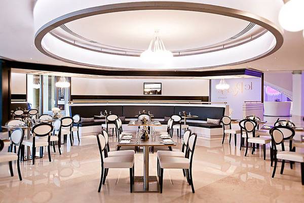 JA Ocean View Hotel Innenbereich mit runden Deckenleuchte und Sitzplätzen.