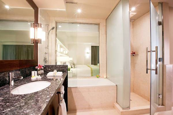 Badezimmer des JA Ocean View Hotels mit Badewanne, Dusche und Waschbecken.