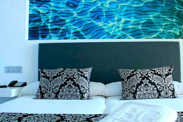 Doppelbett im Hotelzimmer mit Wasser-Wandbild im BG Hotel Nautico Ebeso