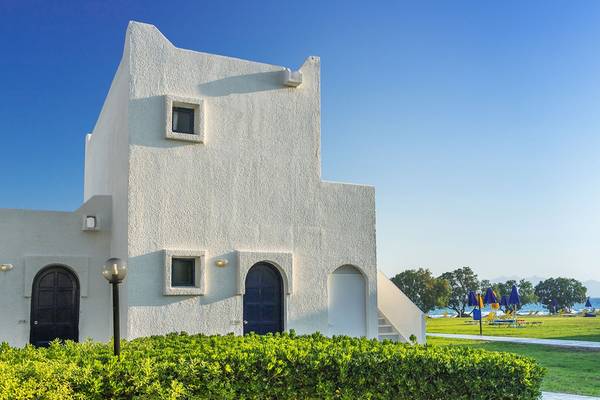 Außenansicht des Aeolos Beach Hotel auf Kos mit weißen Wänden und einer ruhigen Umgebung.