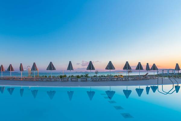 Sonnenuntergang am Pool des Aeolos Beach Hotel auf Kos mit Sonnenschirmen und Liegen