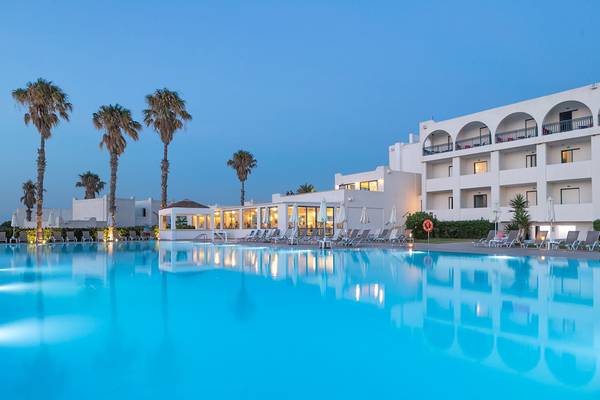 Außenpool des Aeolos Beach Hotel - Kos bei Nacht mit Loungestühlen und Palmen
