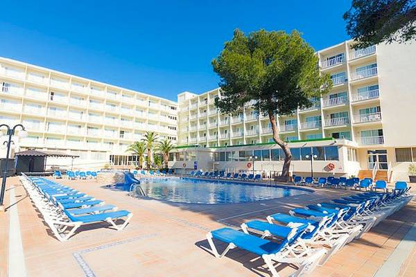 Außenansicht des Hotels Moon Dreams Coral Beach mit Pool und Liegen unter strahlend blauem Himmel.