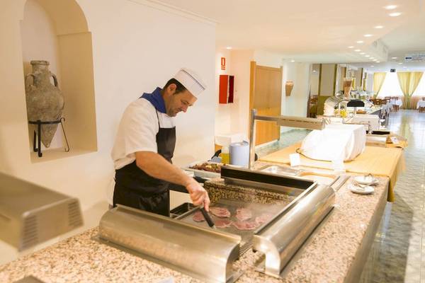 Koch im Moon Dreams Coral Beach Hotel bereitet Fleisch zu.