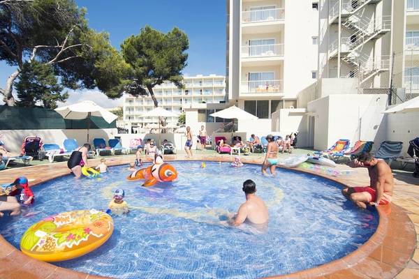 Schwimmbadbereich des Moon Dreams Coral Beach Hotels mit vielen Gästen, die im Wasser und unter Sonnenschirmen entspannen.