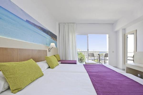 Innenansicht eines Zimmers im Moon Dreams Coral Beach Hotel mit einem großen Bett und Meerblick.