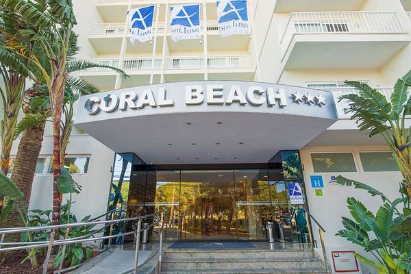 Eingang des Hotels Moon Dreams Coral Beach mit modernen Elementen und tropischer Vegetation.