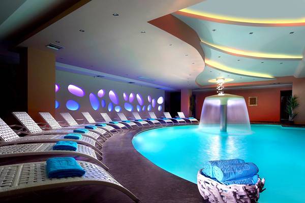 Spa-Bereich des Dimitra Beach Hotel & Suites mit Pool und Liegen.