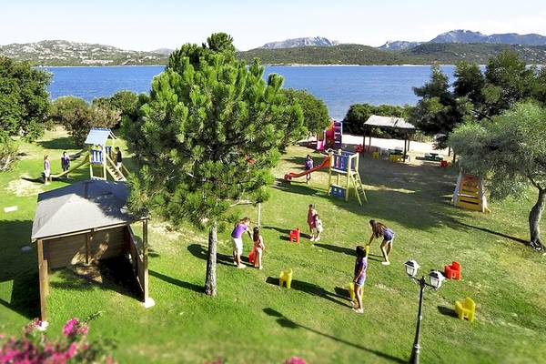 Aussicht auf den Spielplatz im Colonna Hotel Du Golf mit Kindern, die auf einer Wiese spielen.