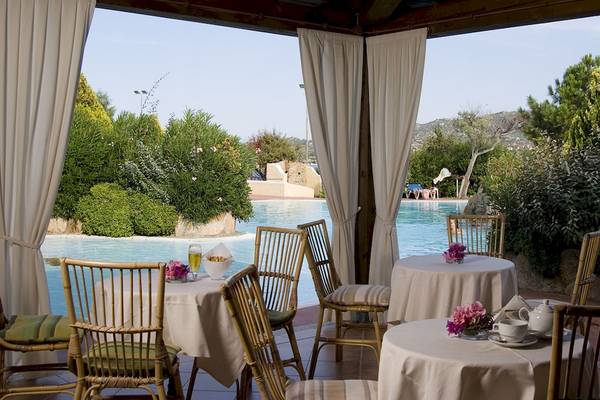 Terrasse im Colonna Hotel Du Golf mit Tischen und Stühlen, Blick auf den Pool