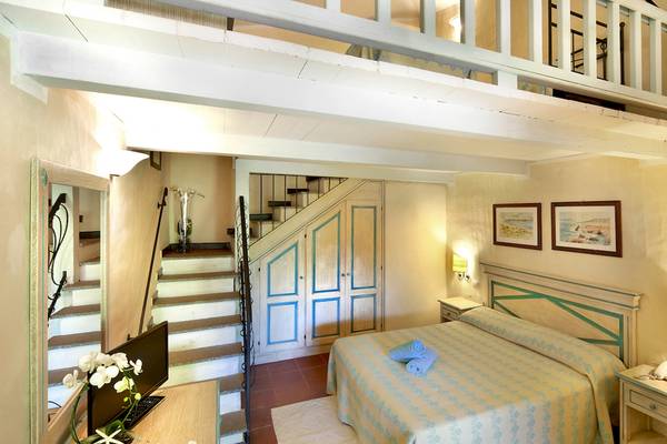 Schlafzimmer mit Bett und Stiege im Hotel Colonna Du Golf