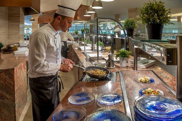 Ein Koch bereitet Gerichte auf einem Buffet im Zafiro Tropic Hotel zu.