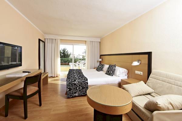 Hotelzimmer mit Bett, Schreibtisch, Fernseher und Sofa im Zafiro Tropic Hotel.