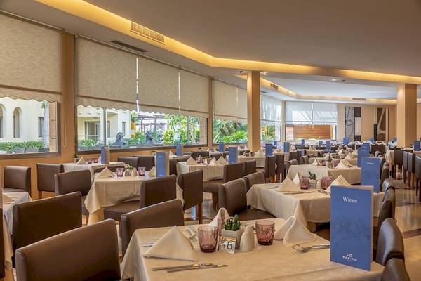 Innenansicht des Restaurants im Zafiro Tropic Hotel mit gedeckten Tischen und Stühlen.