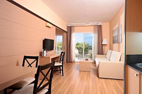 Innenansicht einer Suite im Zafiro Tropic Hotel mit Wohnzimmer, Essbereich und Küche.