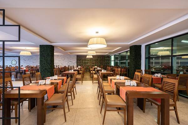 Innenansicht des Restaurants im White City Resort mit gepolsterten Stühlen und Tischen.