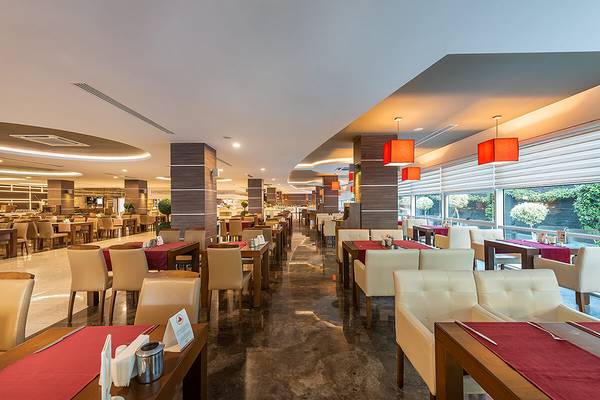 Innenansicht des Restaurants im White City Resort mit gedeckten Tischen und Stühlen.