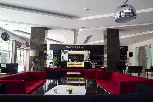 Lobby des White City Resort Hotels mit roten Sofas und einer modernen Einrichtung.