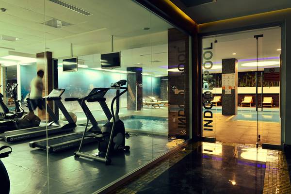 Fitnessstudio im White City Resort mit Laufbändern, einem Pool und einer verglasten Trennwand.