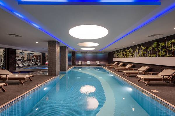 Innenpool des White City Resort mit Lounge-Sesseln und blauen Lichtern