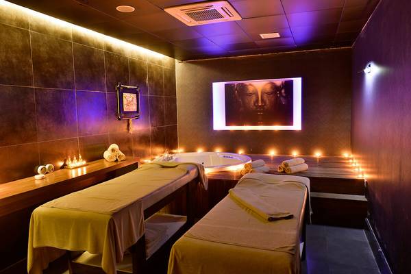 Spa-Behandlungsraum im White City Resort mit zwei Massagetischen, einem Whirlpool und beruhigender Beleuchtung.