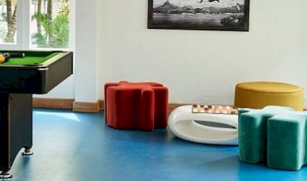 Pooltisch im Hotelraum von The Ravenala Attitude mit bunten Stühlen und Gemälden an der Wand.