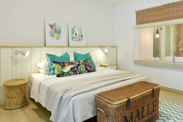 Das Schlafzimmer im Hotel The Ravenala Attitude mit einem großen Bett, Kissen, und einem Korb neben dem Bett.