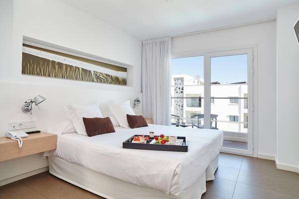 Ein modernes Hotelzimmer mit einem Bett, Frühstücksplatte und einem Fenster mit Terrassenblick.
