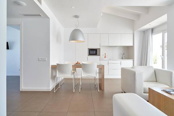 Modernes Innendesign des Ibiza Sun Apartments mit hellen Wänden, weiße Möbel und offene Küche.