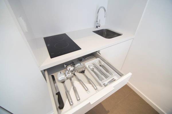 Foto von einer modernen Küche mit einer Kochplatte, einem offenen Schrank mit Kochgeschirr und einer Spüle in Ibiza Sun Apartments.