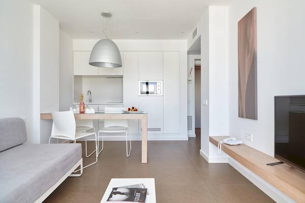 Innenbereich eines modernen Apartments mit Sitzecke, Tisch und Fernseher