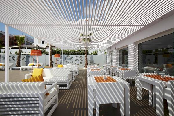 Terrasse mit weißen Sofas und Tischen im Ibiza Sun Apartments Hotel