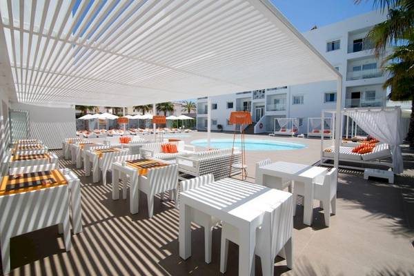 Terrasse mit weißen Möbeln und Sonnenschirmen im Ibiza Sun Apartments