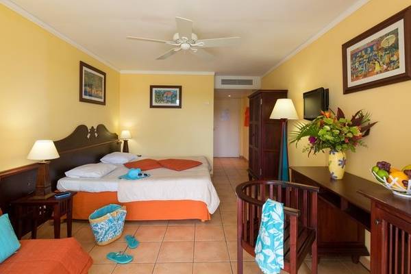 Hotelzimmer im Pierre & Vacances Village Sainte Luce mit Bett, Schreibtisch, Stühlen und Dekor.