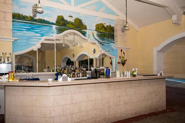 Bar im Iberostar Playa Alameda Hotel mit einer malerischen Wandmalerei und vielen Flaschen.
