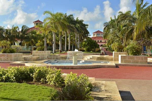 Ein Brunnen vor dem Iberostar Playa Alameda Hotel mit Palmen und Gebäuden im Hintergrund.