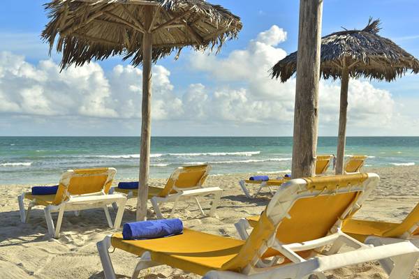 Strand des Iberostar Playa Alameda Hotels mit gelben Liegestühlen und Strohschirmen