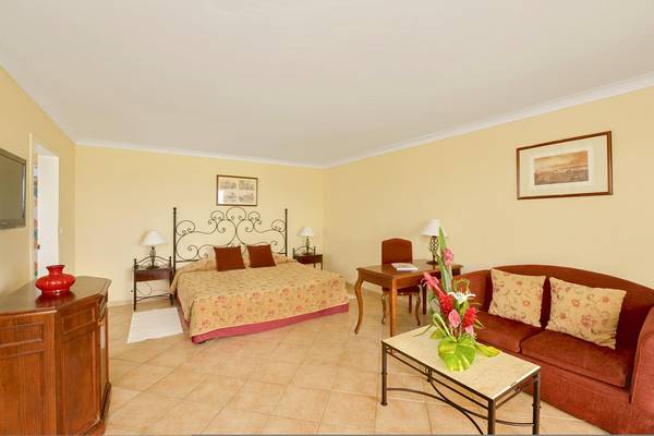 Hotelzimmer im Iberostar Playa Alameda mit Bett, Sofa, Tisch und Dekoration.