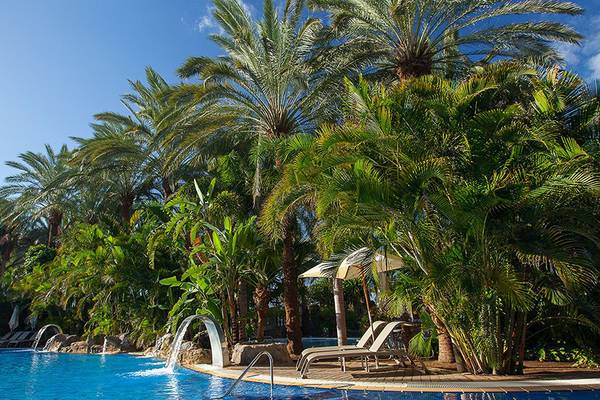 Pool im Lopesan Costa Meloneras Resort & Spa mit Palmen und Sonnenliegen