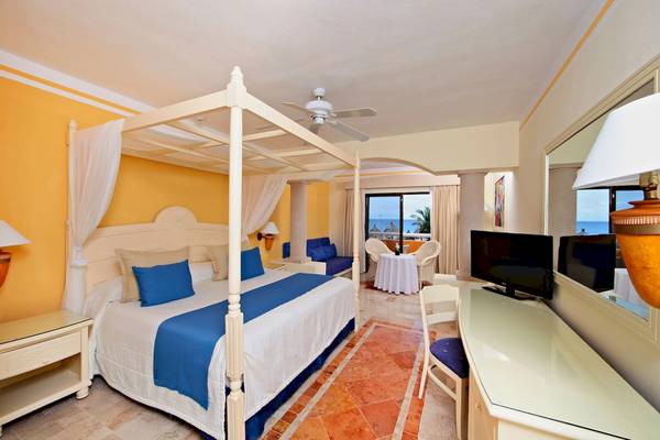 Schlafzimmer im Bahia Principe Luxury Akumal mit Himmelbett, Fernseher und Seeblick