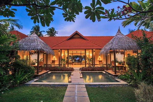 Nachtansicht einer Villa im Kurumba Maldives mit Swimmingpool und umliegenden Pflanzen.