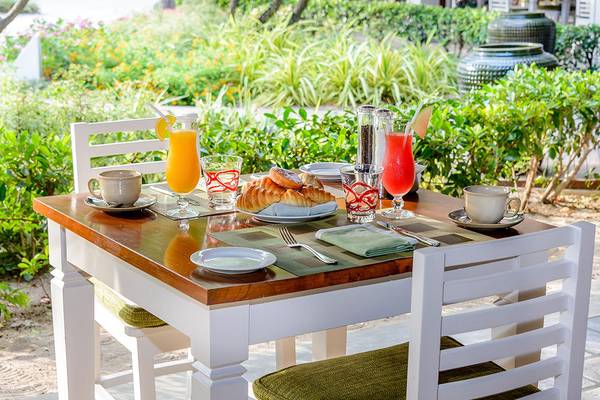 Frühstückstisch im Kurumba Maldives mit Croissants, Orangensaft und Kaffee.