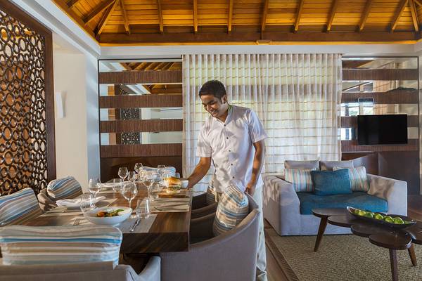 Ein Mann serviert ein Essen in einem luxuriösen Hotelrestaurant des Kurumba Maldives.